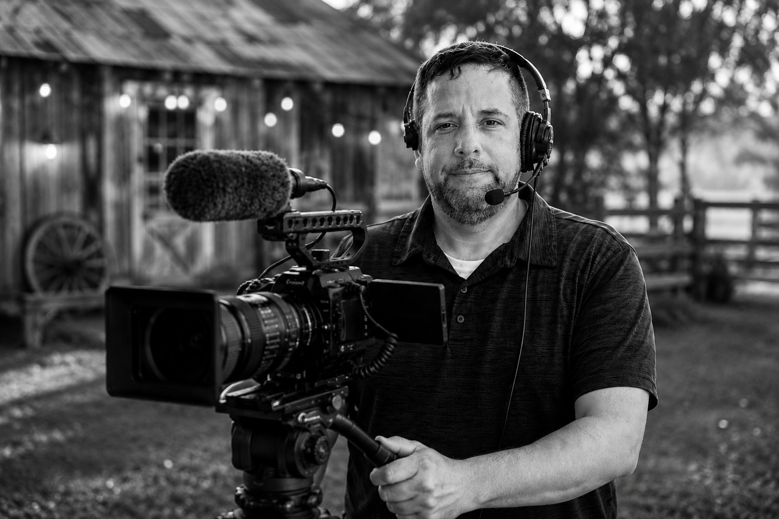 Eric, holding a cinema camera rig and wearing a production headset